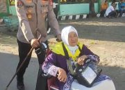 Kapolsek Pattallassang Bantu Dorong Kursi Roda Jamaah Haji Lansia